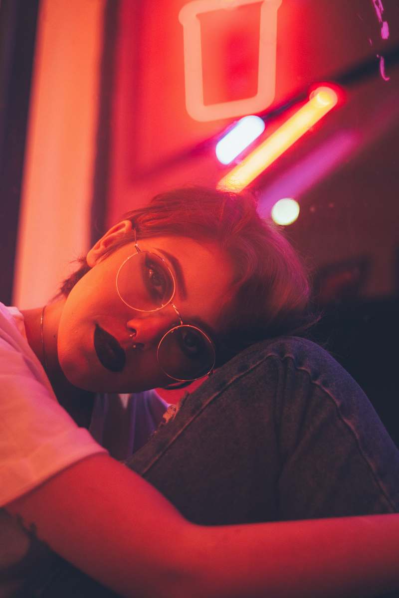 brazil woman leaning on wall with neon light signage red